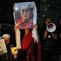 Tibetanos en el exilio con un retrato de su líder espiritual Dalai Lama, y una imagen de un joven tibetano que se inmoló (izq) el día antes, el 30 de septiembre en una vigilia en la localidad india de Dharamsala