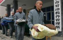 Presos del campo de trabajos forzados X'ian, en la provincia de Shaanxi, hacen cola para recoger edredones en noviembre de 2006. / Lan Shan (Zuma Press)